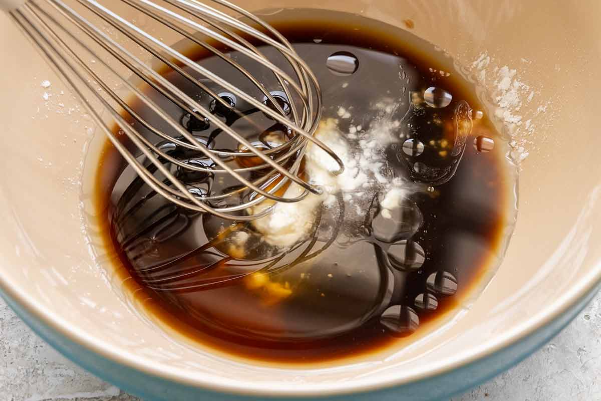 Whisk inside a bowl with soy sauce, oyster sauce, and cornstarch.