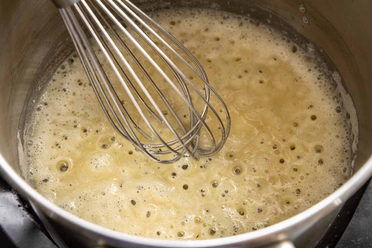 Butter and flour whisked together in a saucepan, forming a bubbling blonde roux.