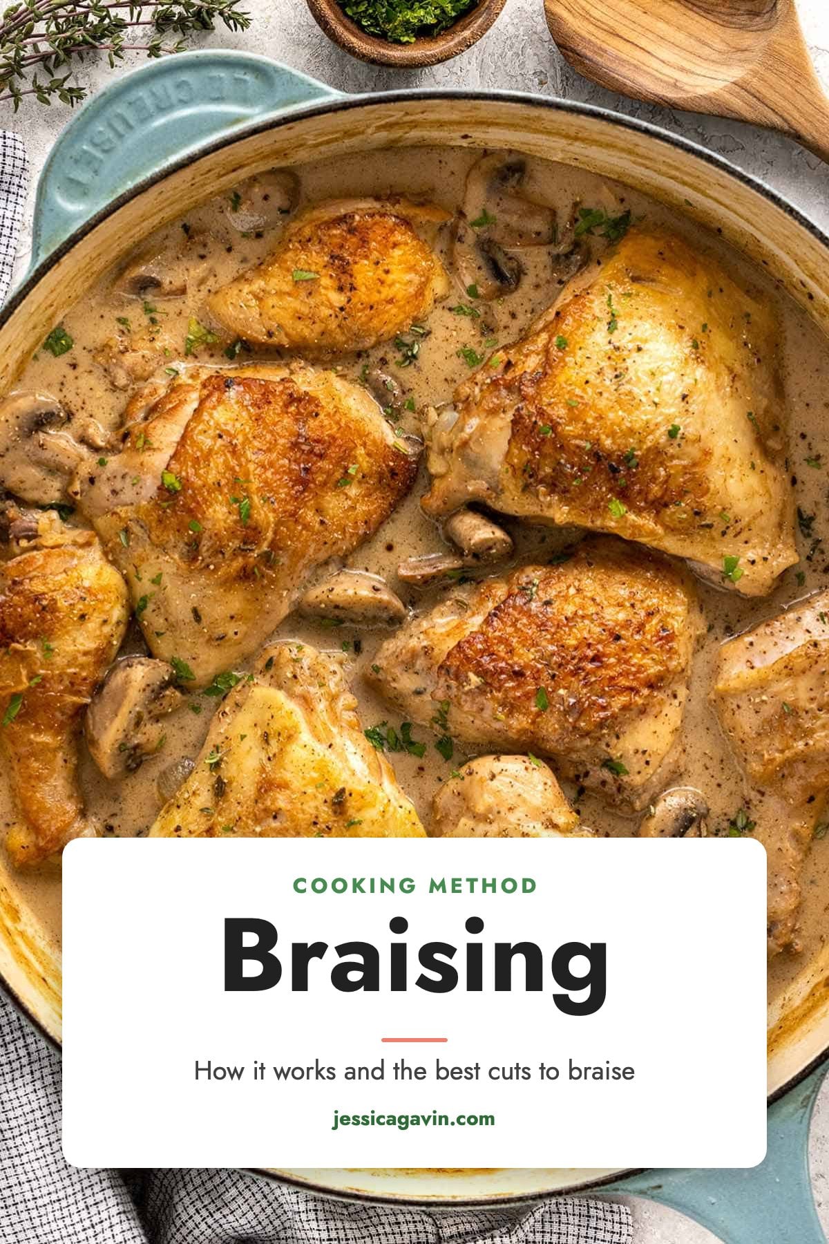 Golden seared chicken thighs braising with mushrooms in a creamy sauce in a Dutch oven.