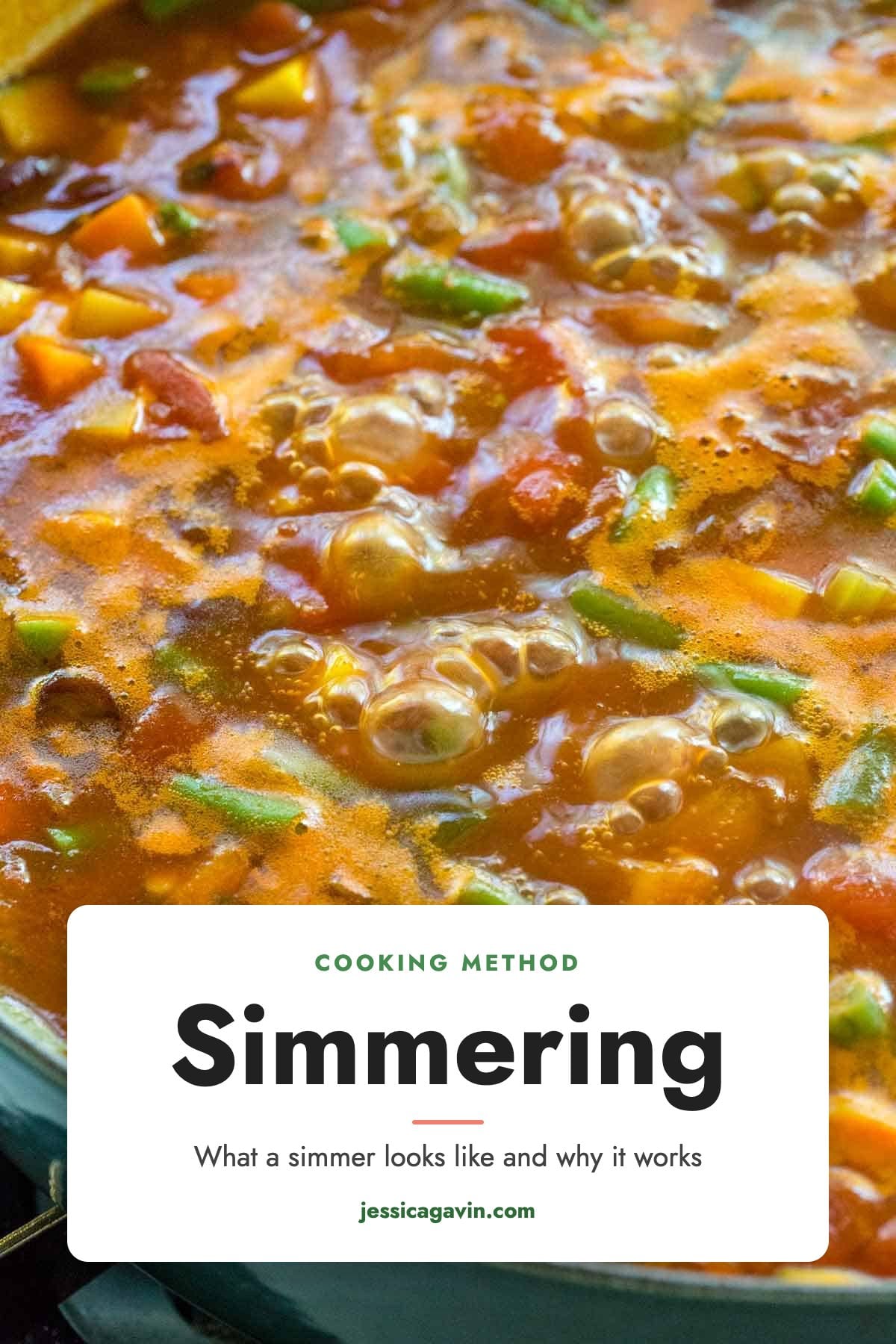 Vegetable soup simmering in a large pot, with small, steady bubbles breaking across the surface.